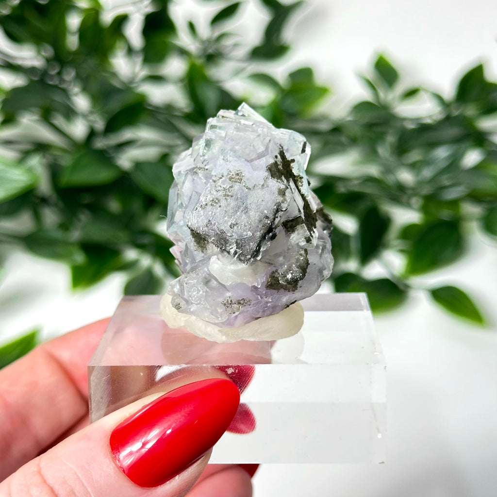 Purple and blue Yaogangxian fluorite crystal specimen held by a hand