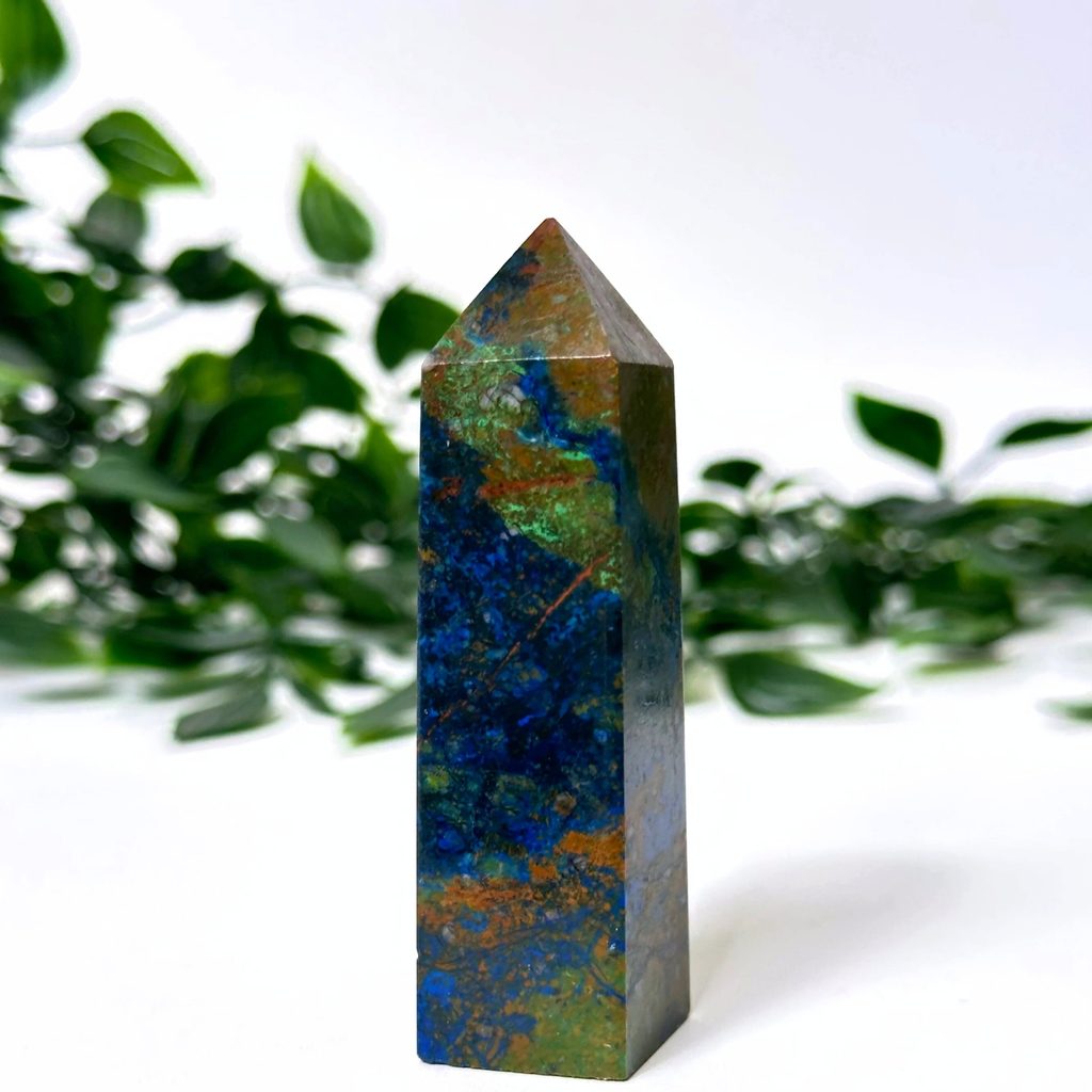 Multicolored crystal tower with a natural green leafy background