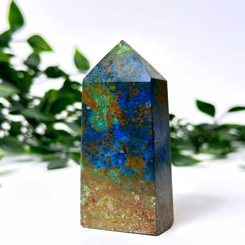 Multicolored crystal tower with a natural green leafy background