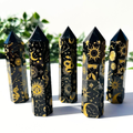 5 black obsidian crystal towers in front of a white and leafy background