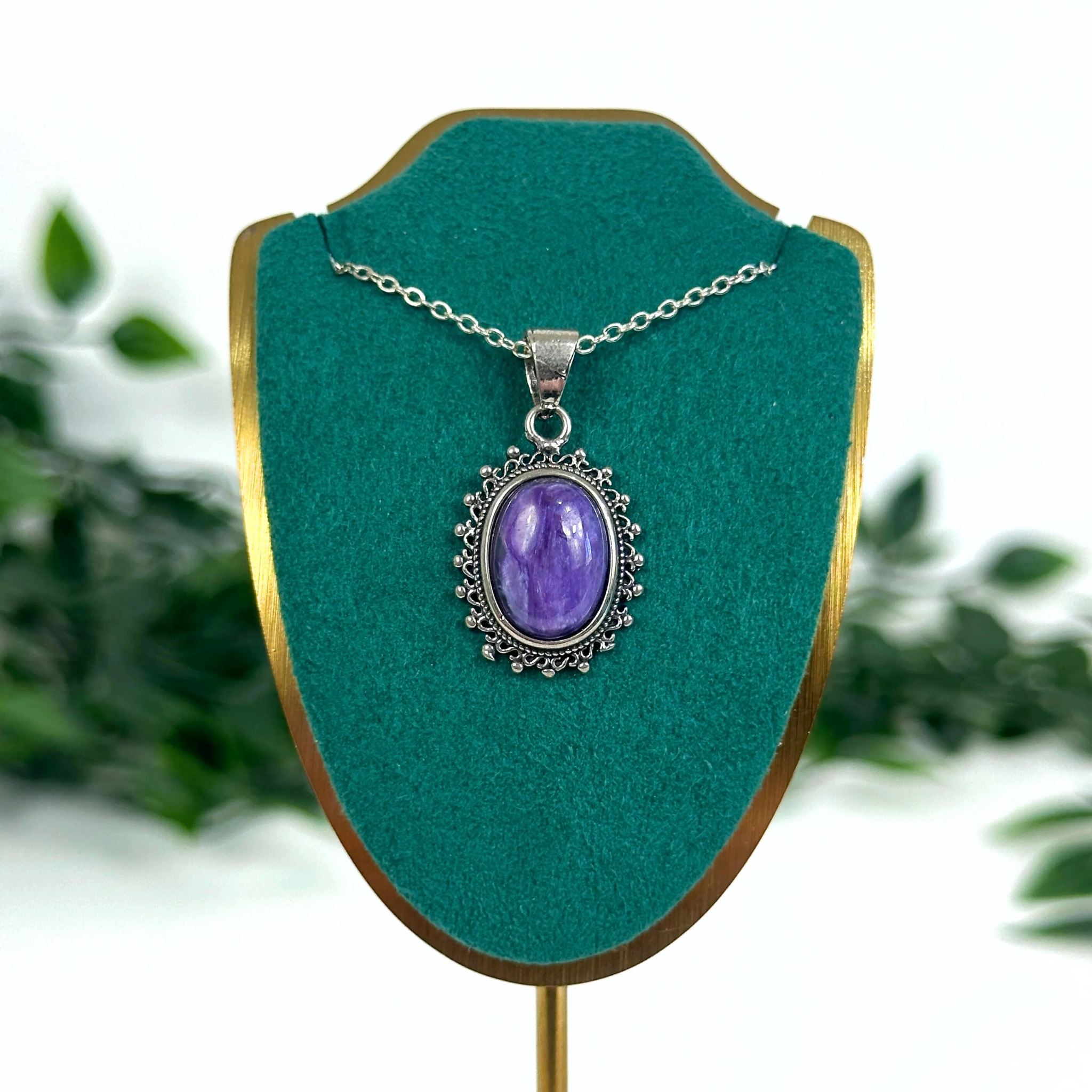Charoite crystal necklace on a jewellery stand on a white background