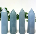 4 angelite crystal towers in front of a white and leafy background