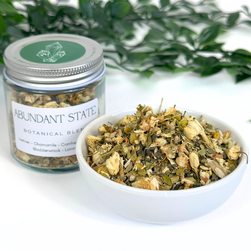 Jar and bowl of Abundant State Botanical Blend with greenery in the background