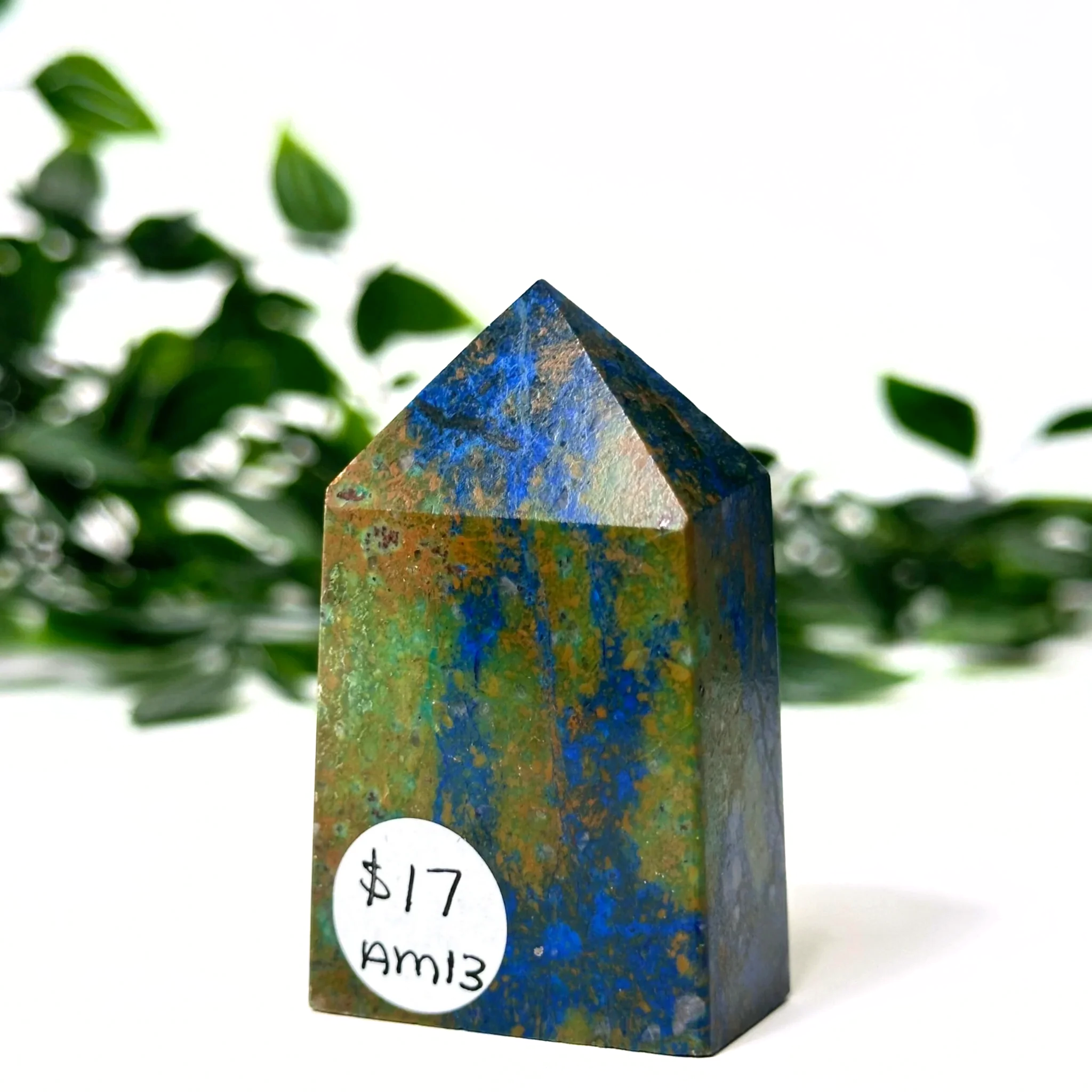 Azurite and malachite crystal tower with blue and green patterns on a white background