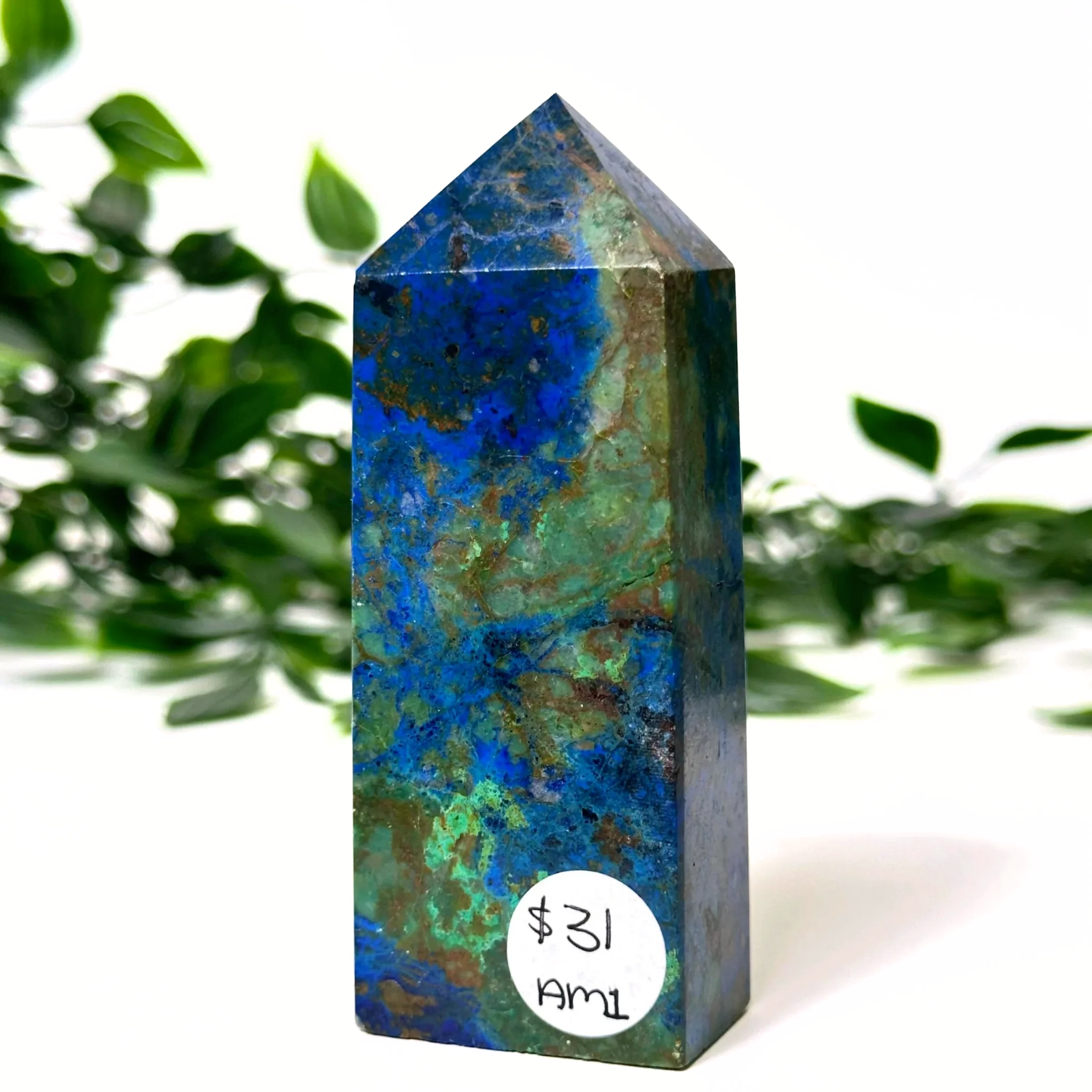 Azurite and malachite crystal tower with a blurred green plant background