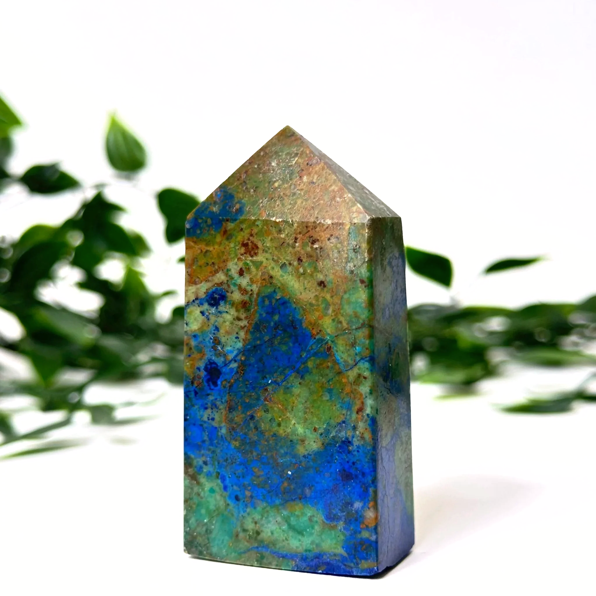 Azurite and malachite crystal tower with blue and green patterns on a white background