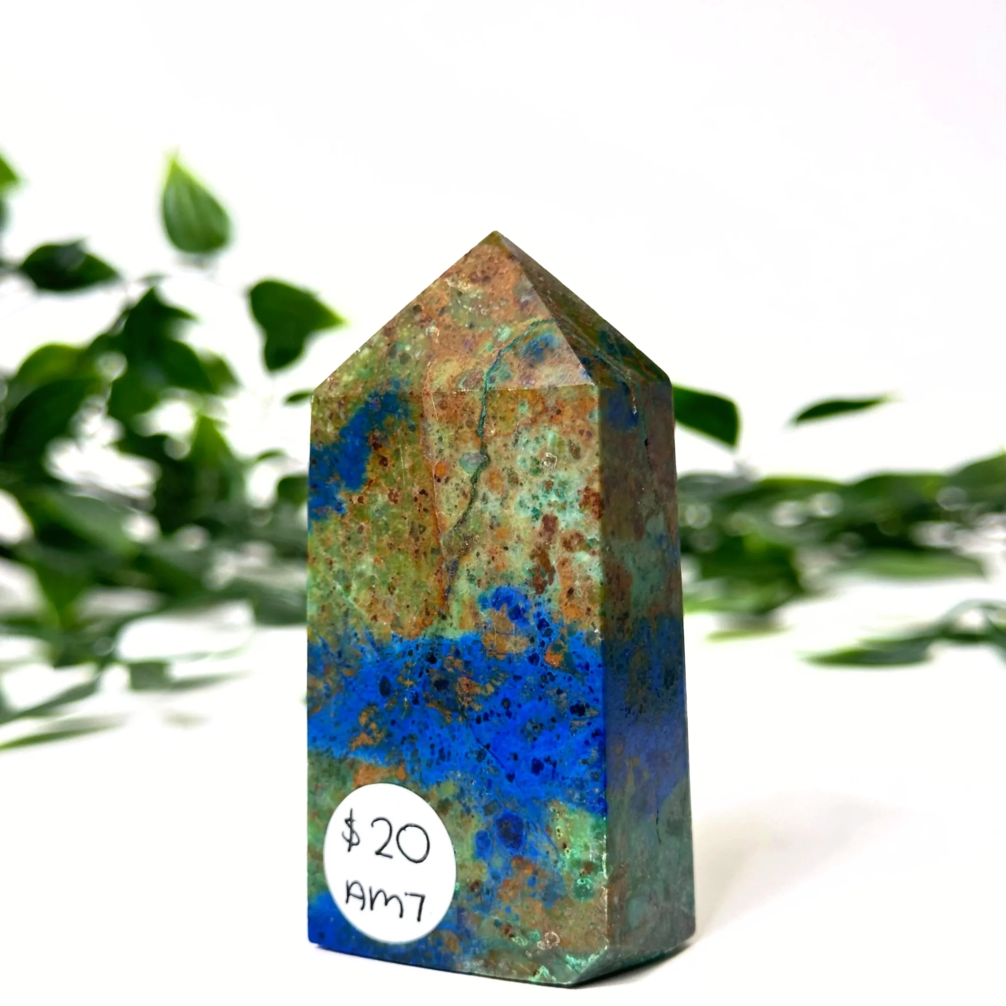 Azurite and malachite crystal tower with blue and green patterns on a white background