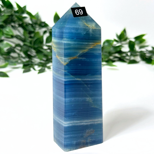 Blue onyx crystal tower against a white background