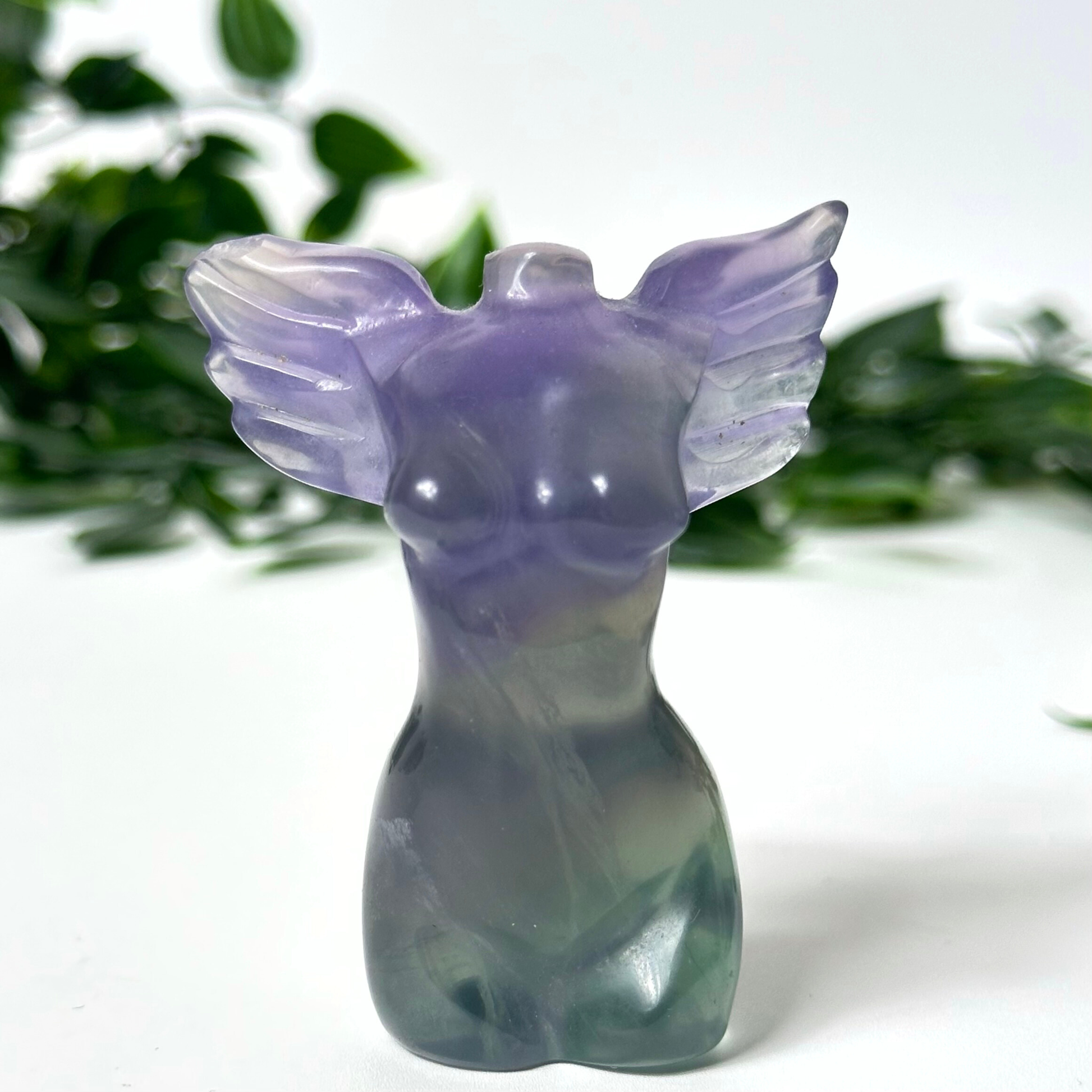 Purple fluorite crystal angel figurine with wings on a white background