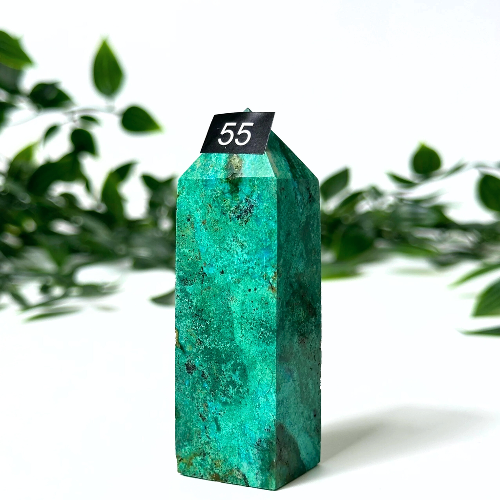 Chrysocolla tower with a black tag labeled '55' on a white background with green leaves.