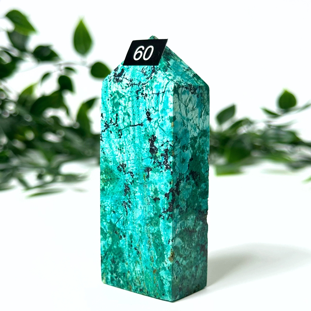 Chrysocolla tower with a number '60' tag against a green leafy background