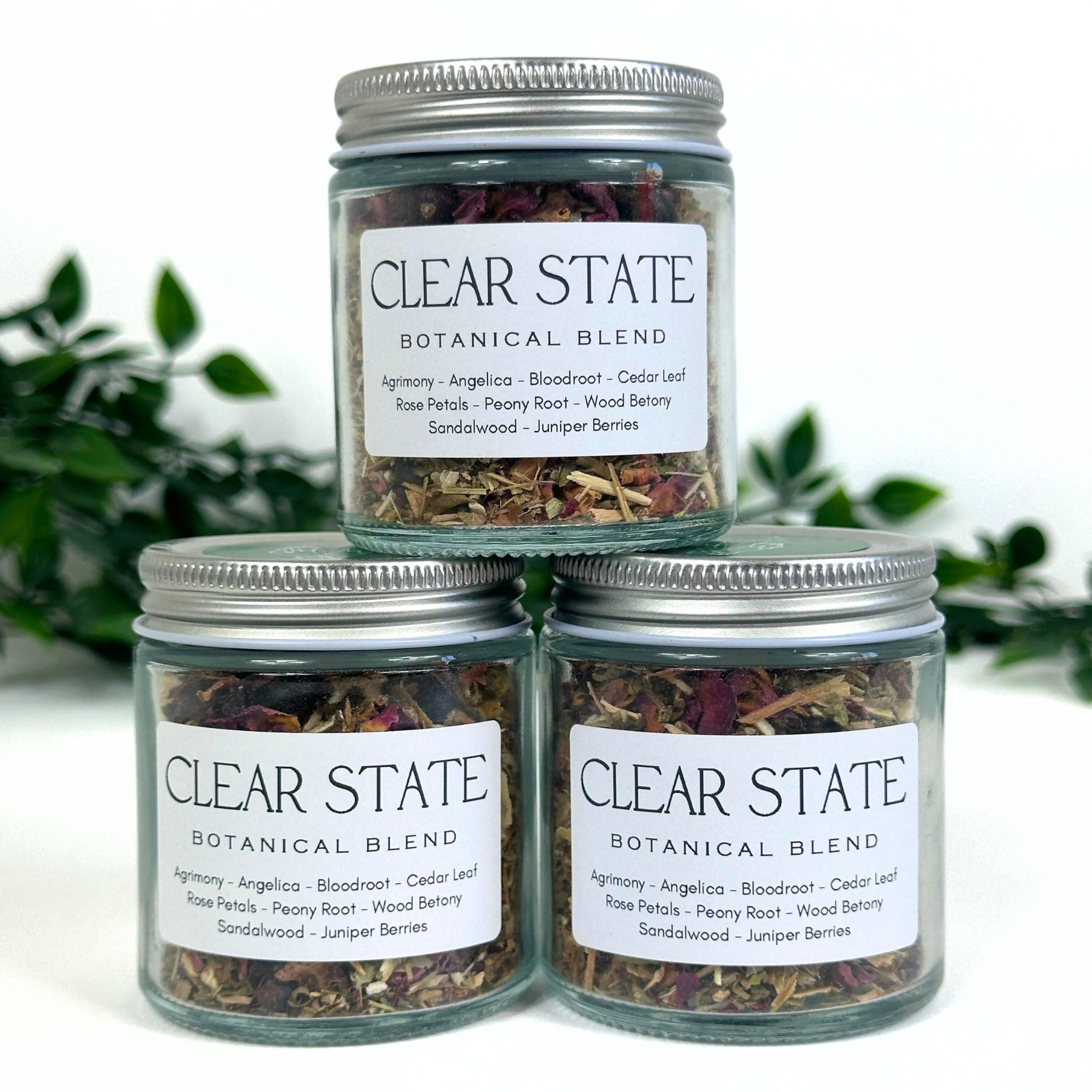 Three jars of Clear State Botanical Blend on a white background with greenery.