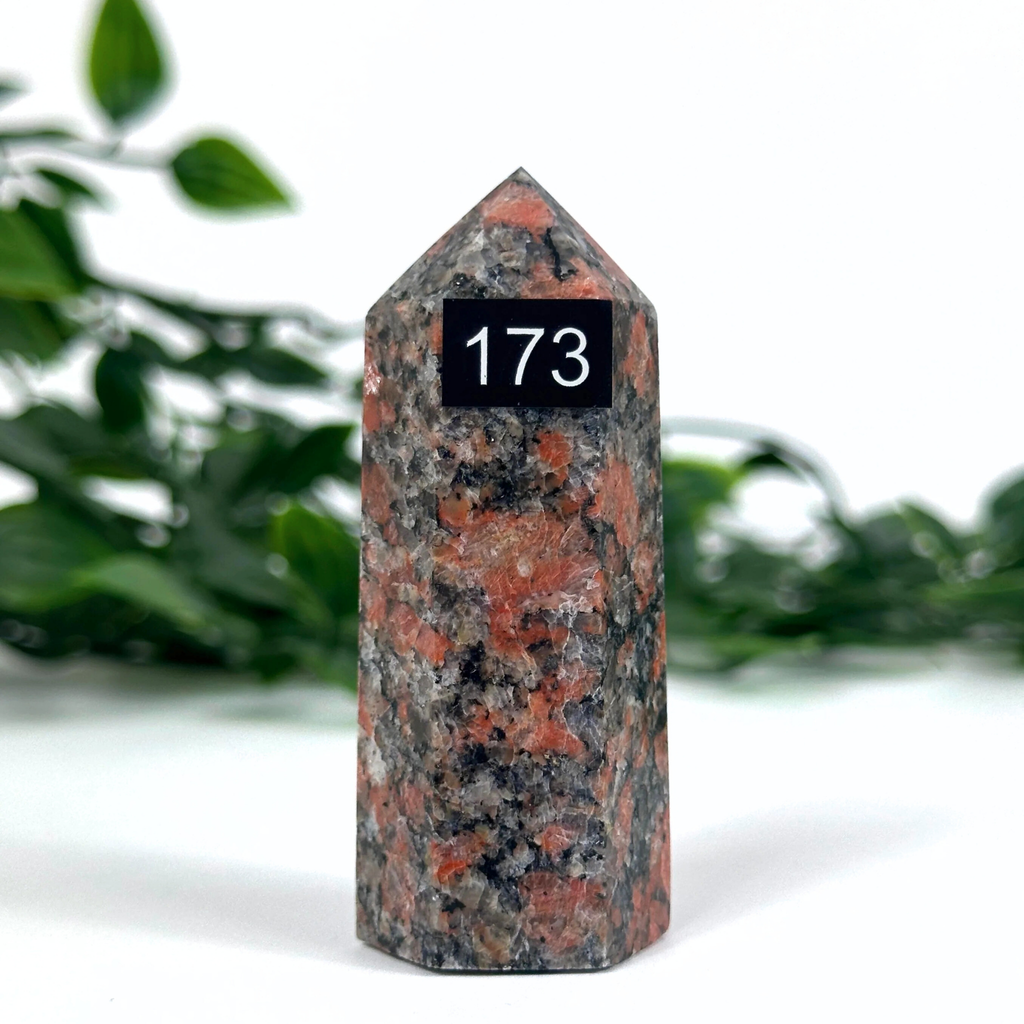 Feldpsar crystal tower against a blurred green foliage background