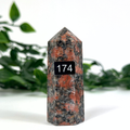 Feldspar crystal tower with orange and grey patterns on a white background