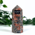 Feldspar crystal tower with orange and brown patterns on a white background