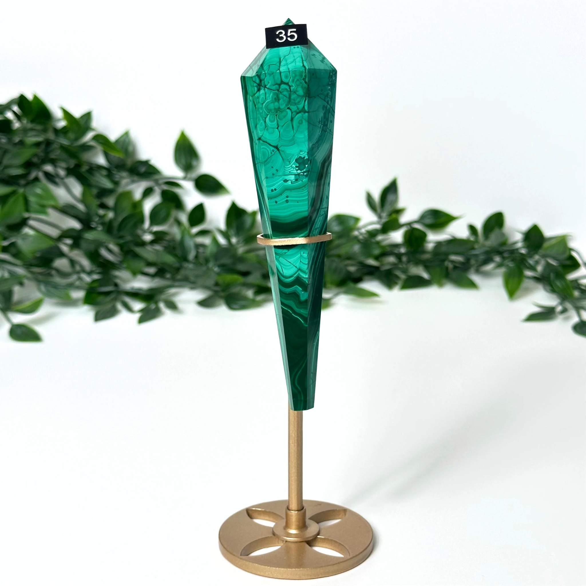 Decorative malachite crystal and gold base on a white background