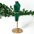 Decorative green malachite crystal wand and gold base on a white background