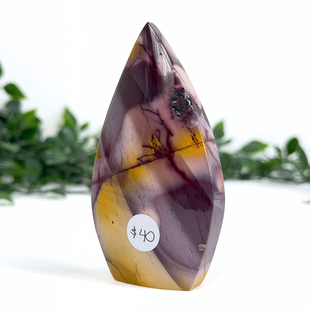 Teardrop shaped mookaite crystal with purple and yellow stone with a price tag on a white background