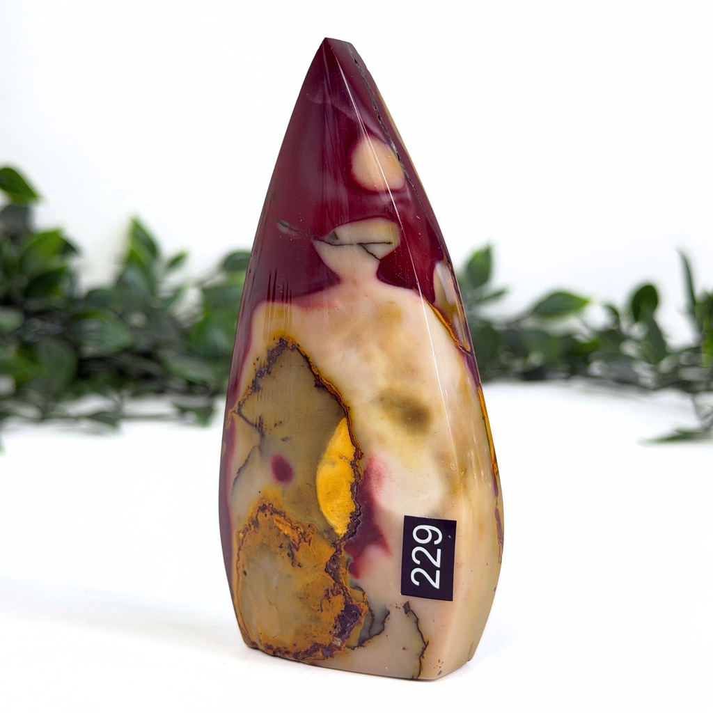 Marbled mookaite stone teardrop with a label on a white background