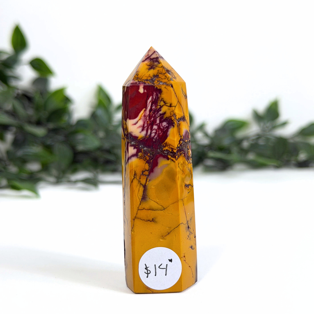 Marbled mookaite crystal tower with a price tag on a white background
