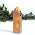 Marbled yellow and purple mookaite crystal tower with a black label on a white background