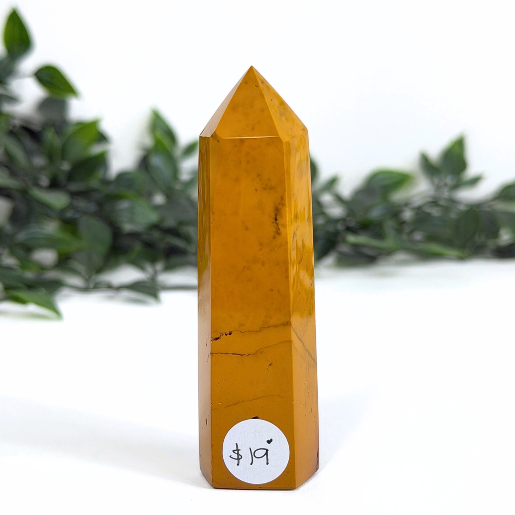 Yellow mookaite crystal tower with a price tag label on a white background