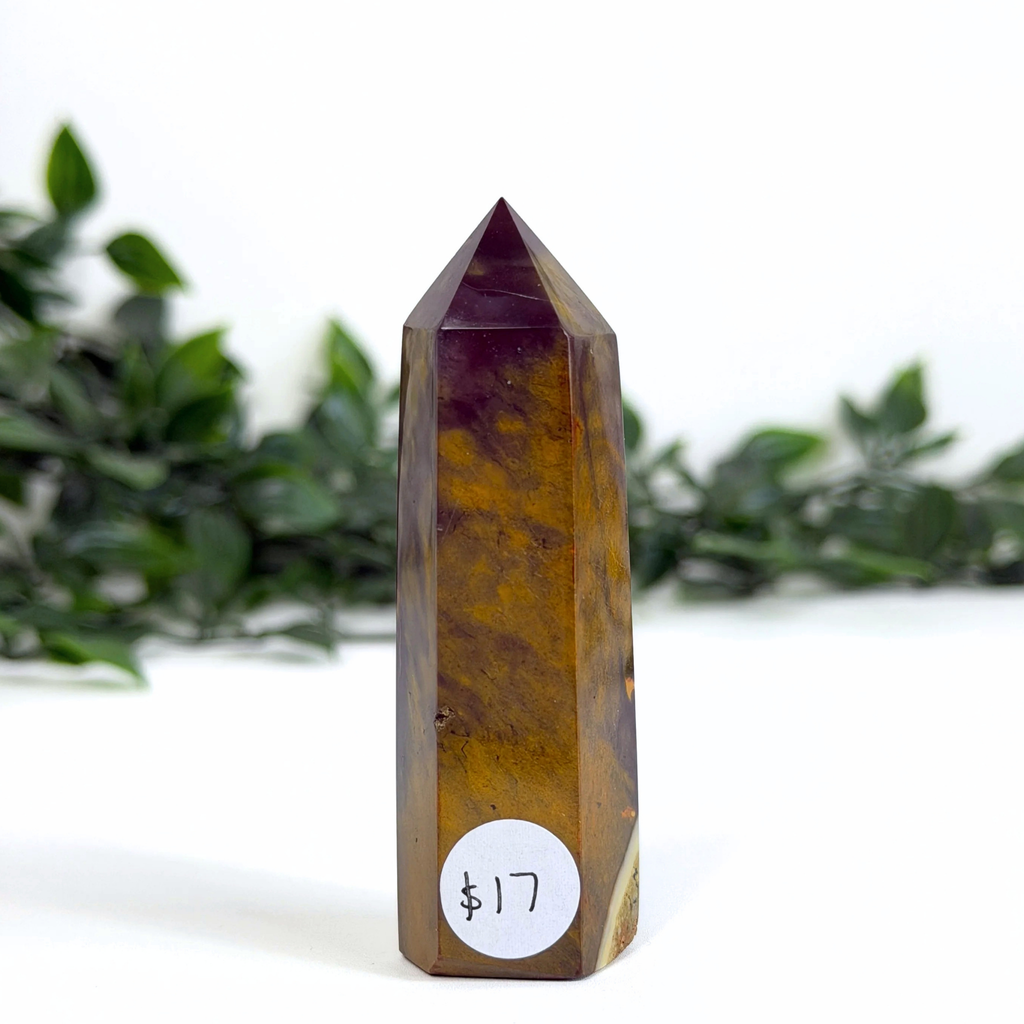 Dark mookaite crystal tower with a price tag on a white background with greenery