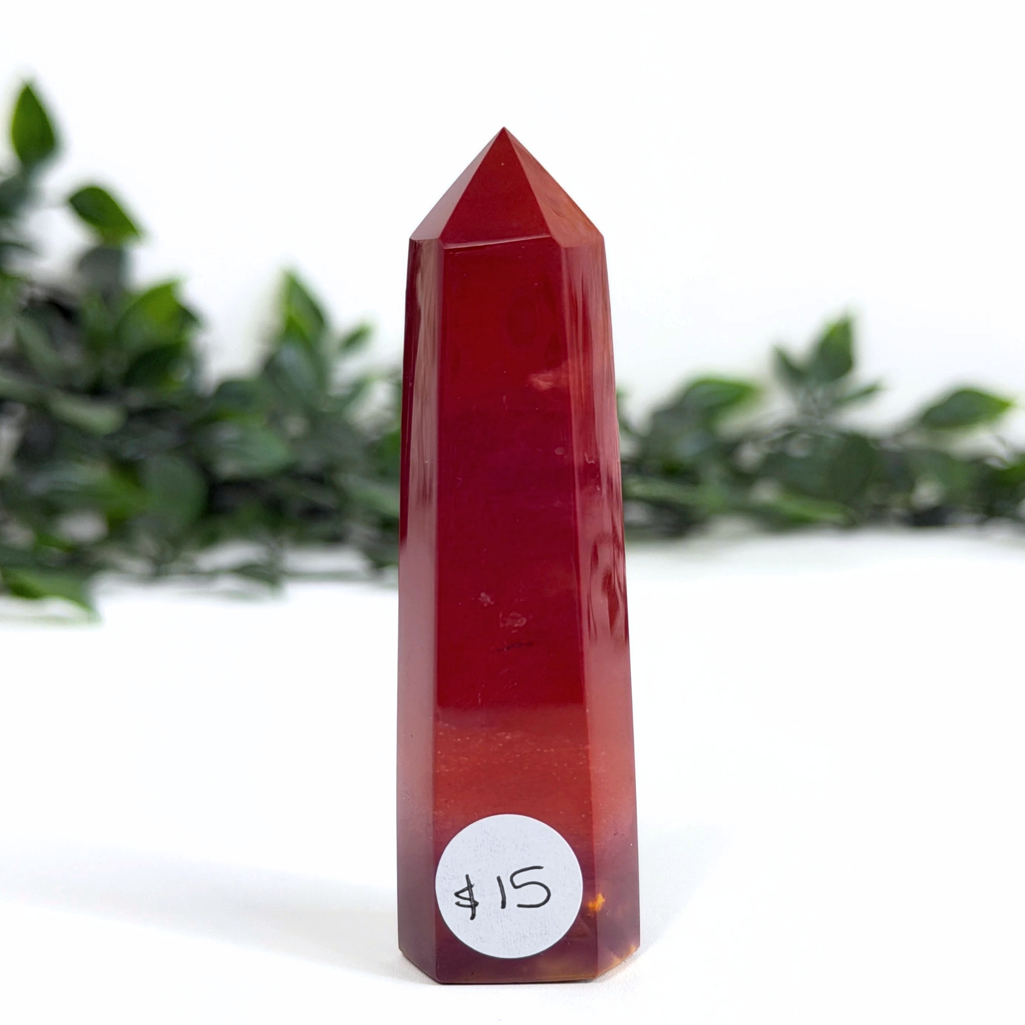 Red mookaite crystal tower with a price tag on a white background