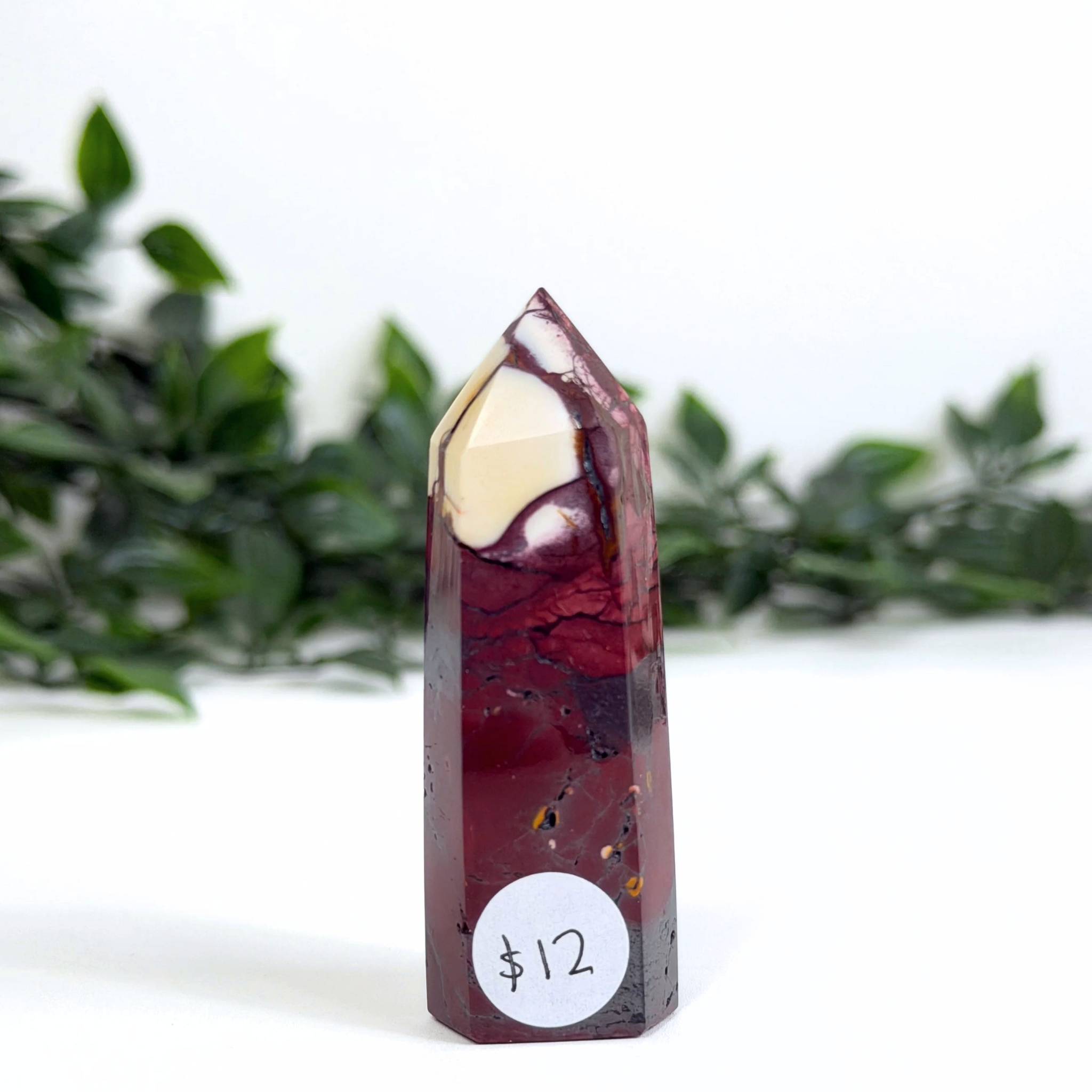 Mookaite crystal tower with a price tag on a white background