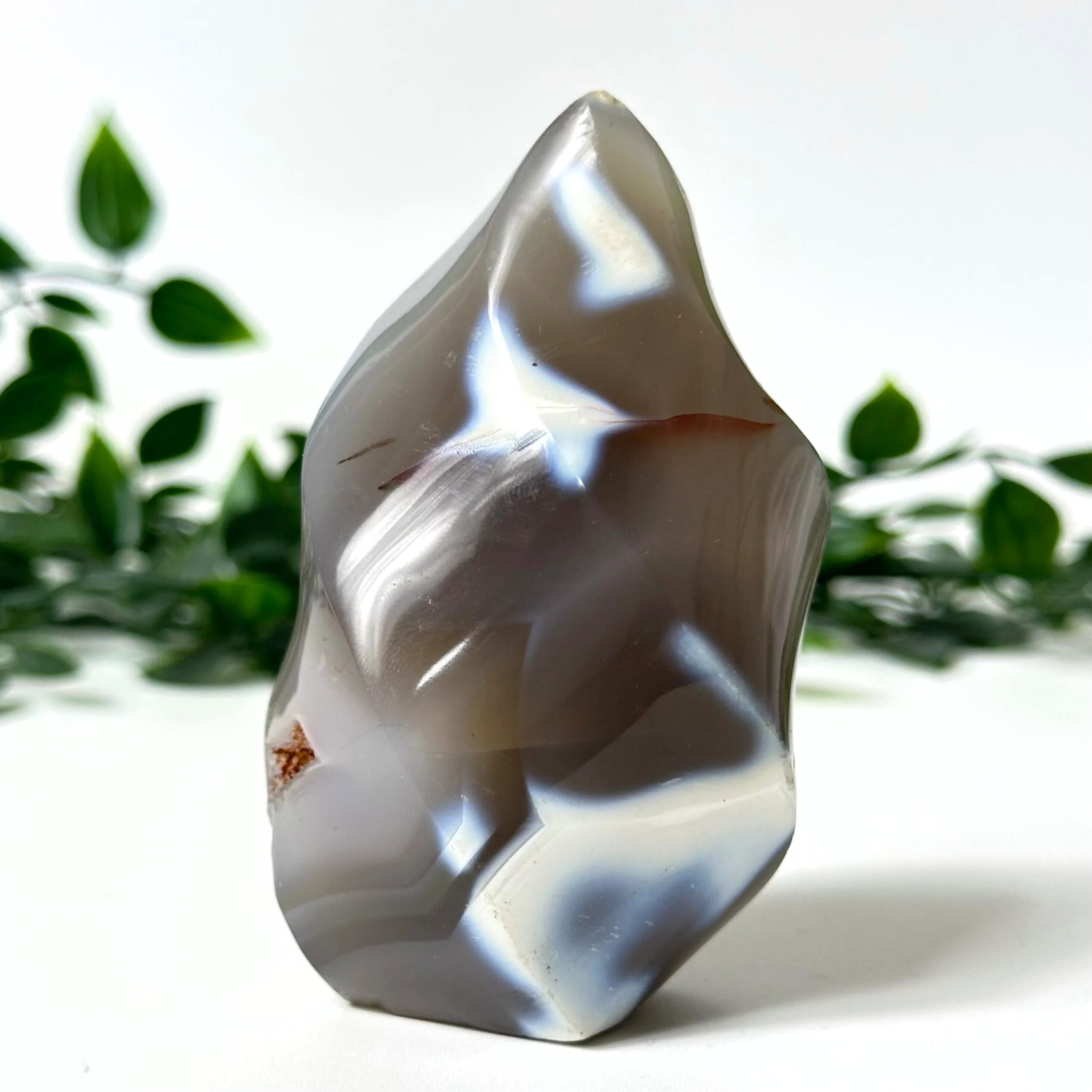 Polished agate agate crystal flame with a natural pattern on a white background