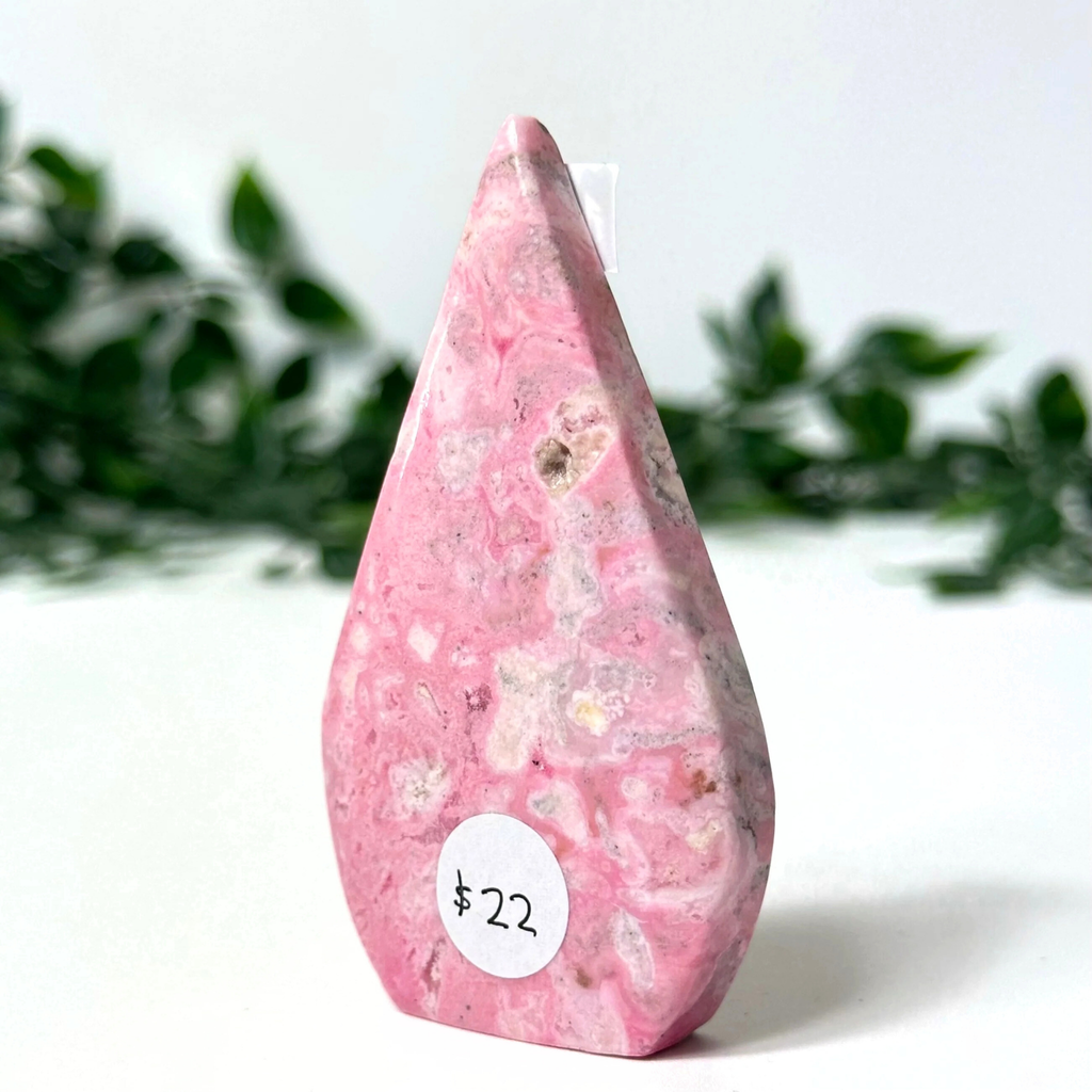 Pink peruvian rhodonite crystal flame on a white background