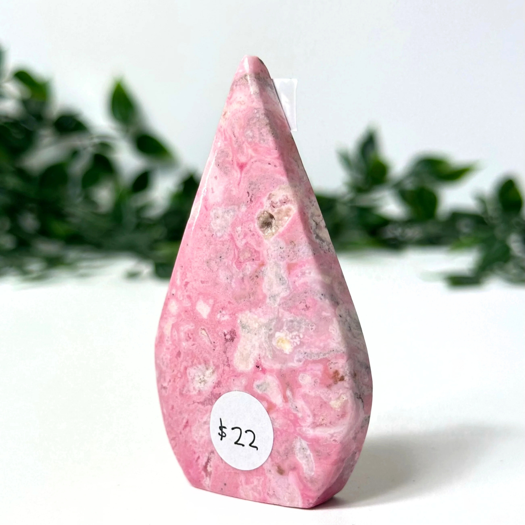 Pink peruvian rhodonite crystal flame on a white background