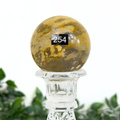 Decorative mookaite sphere with a stand on a white background