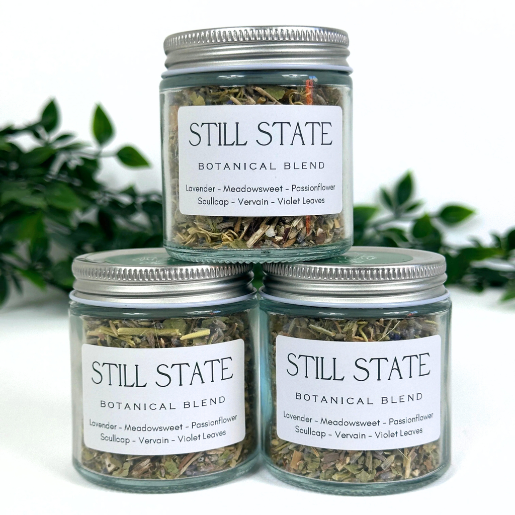 Three jars of 'Still State Botanical Blend' with labels on a white background