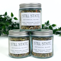 Three jars of 'Still State Botanical Blend' with labels on a white background